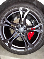 Close-up of a Chevrolet Camaro SS 1LE wheel with red brake caliper and performance tire.