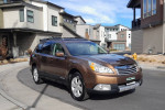 2012 Subaru Outback 2.5i AWD parked on a residential street, showcasing its brown exterior and distinctive design.