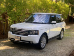 2012 Land Rover Range Rover Supercharged in white, parked amidst greenery, showcasing its sleek design.