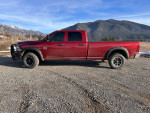 2012 Ram 2500 Power Wagon in red, showcasing its rugged exterior and mountains in the background.