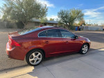 2013 Volvo S60 T5 sedan in red parked on the street with a clear sky
