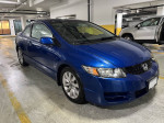 2010 Honda Civic EX FWD blue car parked indoors, well maintained with low mileage.