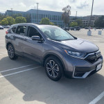 2021 Honda CR-V EX FWD parked in a lot, showing sleek design and alloy wheels.