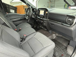 Interior of a well-maintained Ford F-150 with black seats and WeatherTech floor mats.
