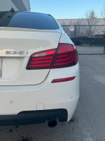 Rear view of a white 2011 BMW 535xi M-sport sedan with a clean title and no accidents.