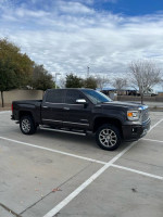 2015 GMC Sierra Denali with Z71 package in a parking lot, showcasing its sleek design and premium features.