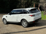 2016 Land Rover Range Rover Sport in Fuji White with panoramic roof and third-row seating, parked outdoors.