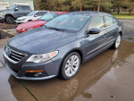 2009 Volkswagen CC sedan with low mileage and new parts, parked on a wet driveway with shiny tires.