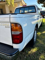 White Toyota Tacoma SR5 with new tires, showing rear view and clean condition, ready for work or play.