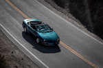1997 Chevrolet Camaro Z28 driving on a scenic road, showcasing its sporty design and vibrant color.