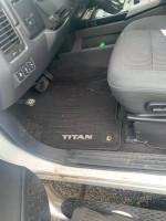 Interior view of 2013 Nissan Titan SV showing the driver's seat and floor mat with 'TITAN' logo