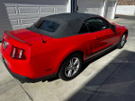 Red 2012 Ford Mustang convertible parked, showcasing its stylish design and well-maintained exterior.