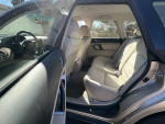 Interior view of a 2008 Subaru Outback showing spacious backseat area with light beige upholstery.