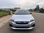 2019 Subaru Impreza in silver with 26,000 miles, featuring a sleek design and clean black interior, parked on a street.