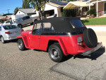 1950 Willys Jeepster Resto Rod on Chevy frame with new upholstery and convertible top parked on a sunny street.