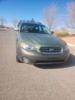 2005 Subaru Outback with 142,000 miles, all-wheel drive, parked on a sunny street.