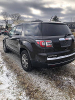 2014 GMC Acadia in excellent condition with all-wheel drive and loaded options, parked on a gravel surface.