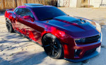 2013 Chevrolet Camaro ZL1 in red, showcasing its sleek design and performance features, parked outdoors.