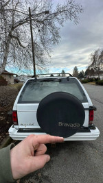Rear view of a 1993 Oldsmobile Bravada SUV with spare tire cover visible on a residential street.