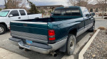 1996 Dodge Ram 2500 Cummins in blue, showcasing its long bed and extended cab design in a parking lot.