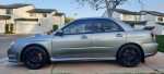 2007 Subaru Impreza WRX STI in gray parked in a residential area, showcasing stylish design and sport wheels.