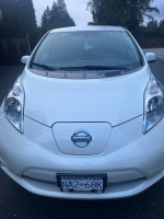 Front view of a white 2017 Nissan LEAF S, showcasing its sleek design and eco-friendly features.