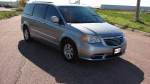 2013 Chrysler Town & Country Touring minivan on the road, featuring a sleek silver design.