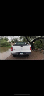Rear view of a 2006 Ford F150 XL with low mileage parked in a residential area
