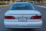 Rear view of a 1992 Ford Taurus SHO in white, showcasing its clean design and 16-inch alloy wheels.