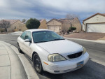 2002 Mercury Sable for sale, showing its exterior with minor scratches and new tires on a suburban street.