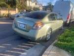 2007 Nissan Altima 3.5SE in green, parked on the street with aluminum wheels and new tires.