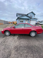 2000 Honda Accord LX FWD in red, parked outside a house with a clear sky, showcasing its side profile.