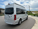 Low mileage silver 2022 Airstream Interstate 19 RV van parked, showcasing its sleek design and 4x4 capability.