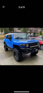 2007 Toyota FJ Cruiser in blue with 35-inch tires and off-road features parked outdoors