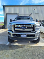 Front view of a 2016 Ford F250 Super Duty truck with chrome grille and aftermarket accessories.