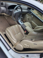 Interior view of a well-maintained 2006 Infiniti G35 Coupe with beige leather seats and modern features.