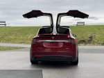 2016 Tesla Model X P90D with Falcon Wing doors open, showcasing sleek design and performance features.