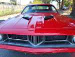 Front view of a classic red 74 Plymouth Cuda for sale, showcasing its sleek design and clean lines.